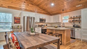 Une cuisine spacieuse avec des meubles en bois, un îlot central et un coin repas équipé de bancs.
