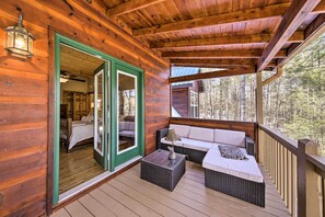 A wooden cabin with a porch featuring wicker furniture and a bed. - Stunning Blue Ridge Retreat w/ River Access! (Blue Ridge)