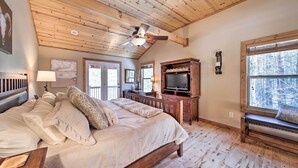 A spacious bedroom with a large bed, wooden ceiling, and a television. - Stunning Blue Ridge Retreat w/ River Access! (Blue Ridge)