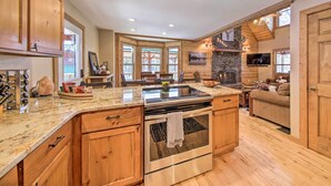 A spacious kitchen with wooden cabinets, a granite countertop, and a built-in oven. - Stunning Blue Ridge Retreat w/ River Access! (Blue Ridge)