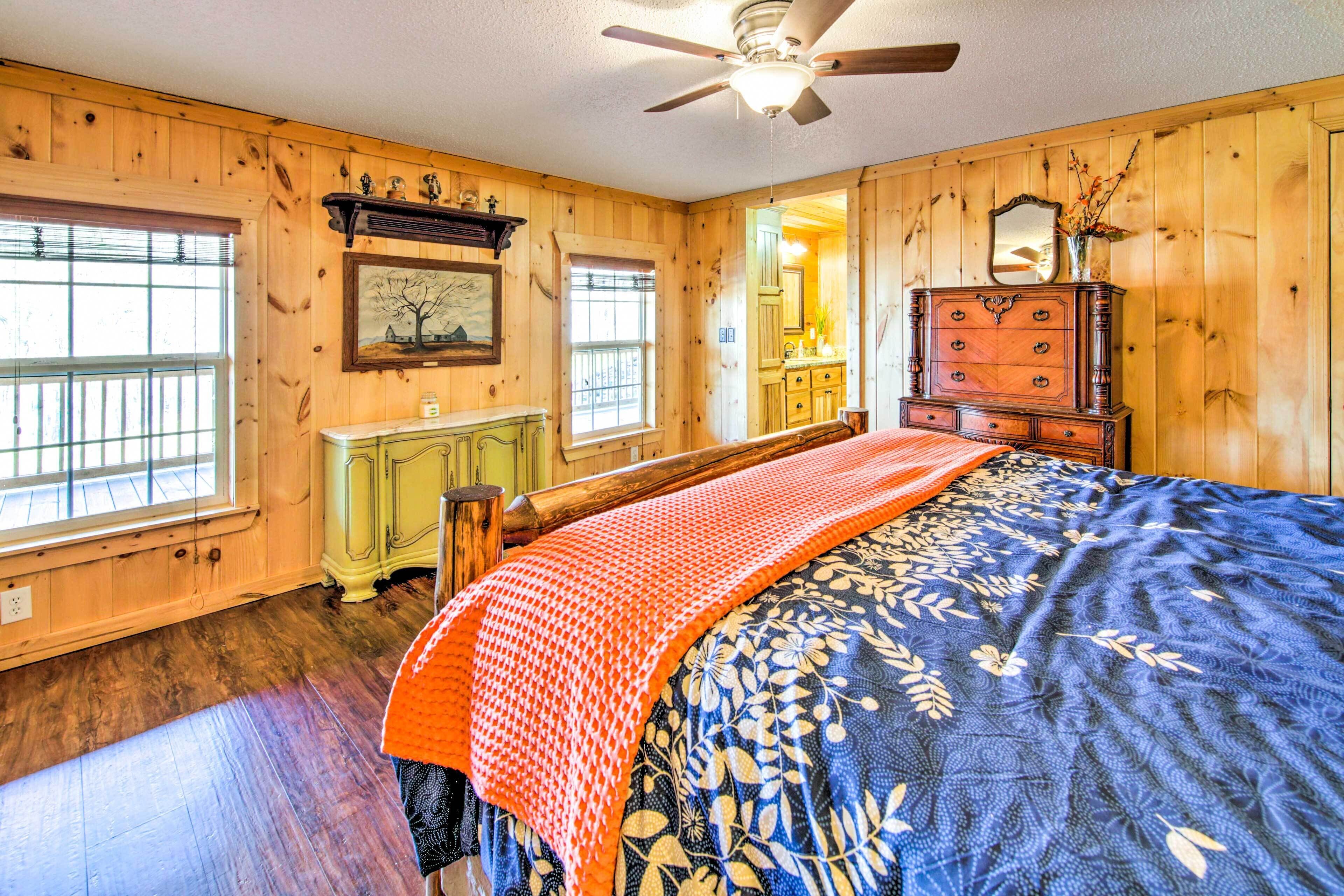 A wooden-paneled room with a bed, dresser, and a window.
