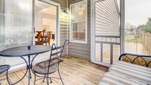 A covered patio with a round table and chairs, a bench, and a sliding glass door leading to an interior space with a dining table and chairs. - Peaceful Savannah Home - 11 Mi to Beaches! (Savannah)