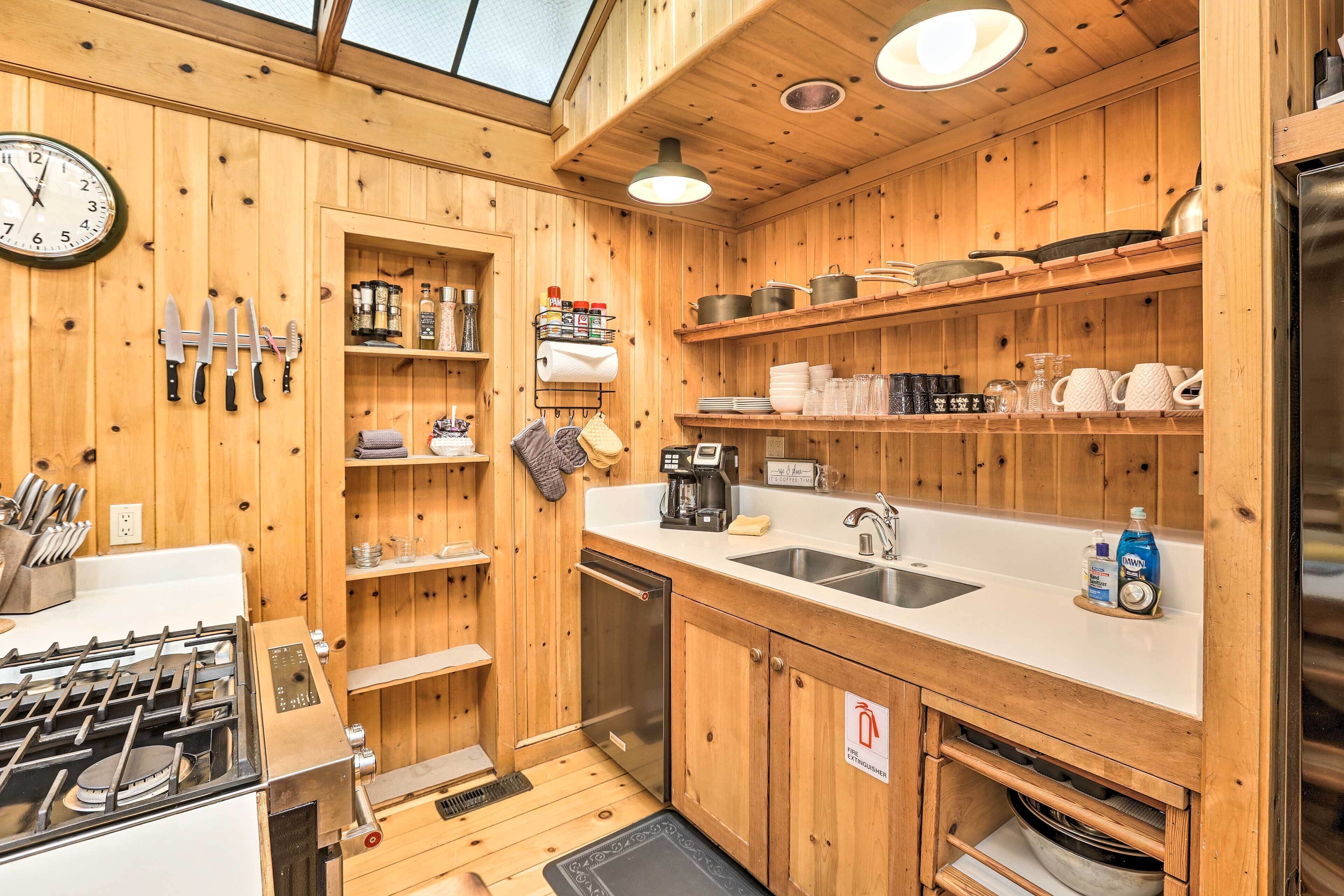 Un intérieur en bois comprenant un espace cuisine équipé d’un fourneau, d’un évier et de divers ustensiles de cuisine.