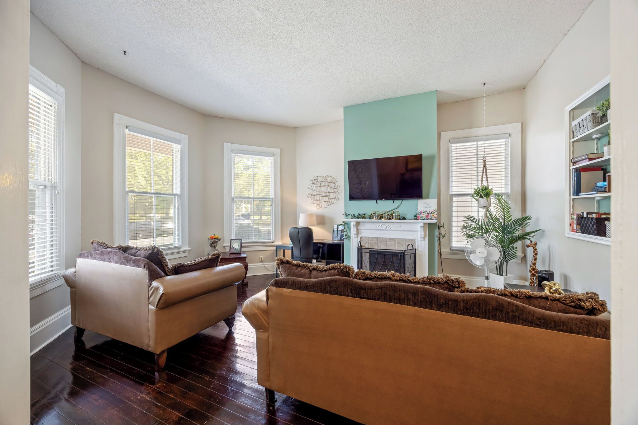 A living room with a fireplace, a television, and a bookshelf.
