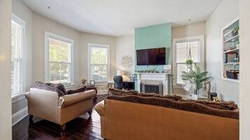 A living room with a fireplace, a television, and a bookshelf.