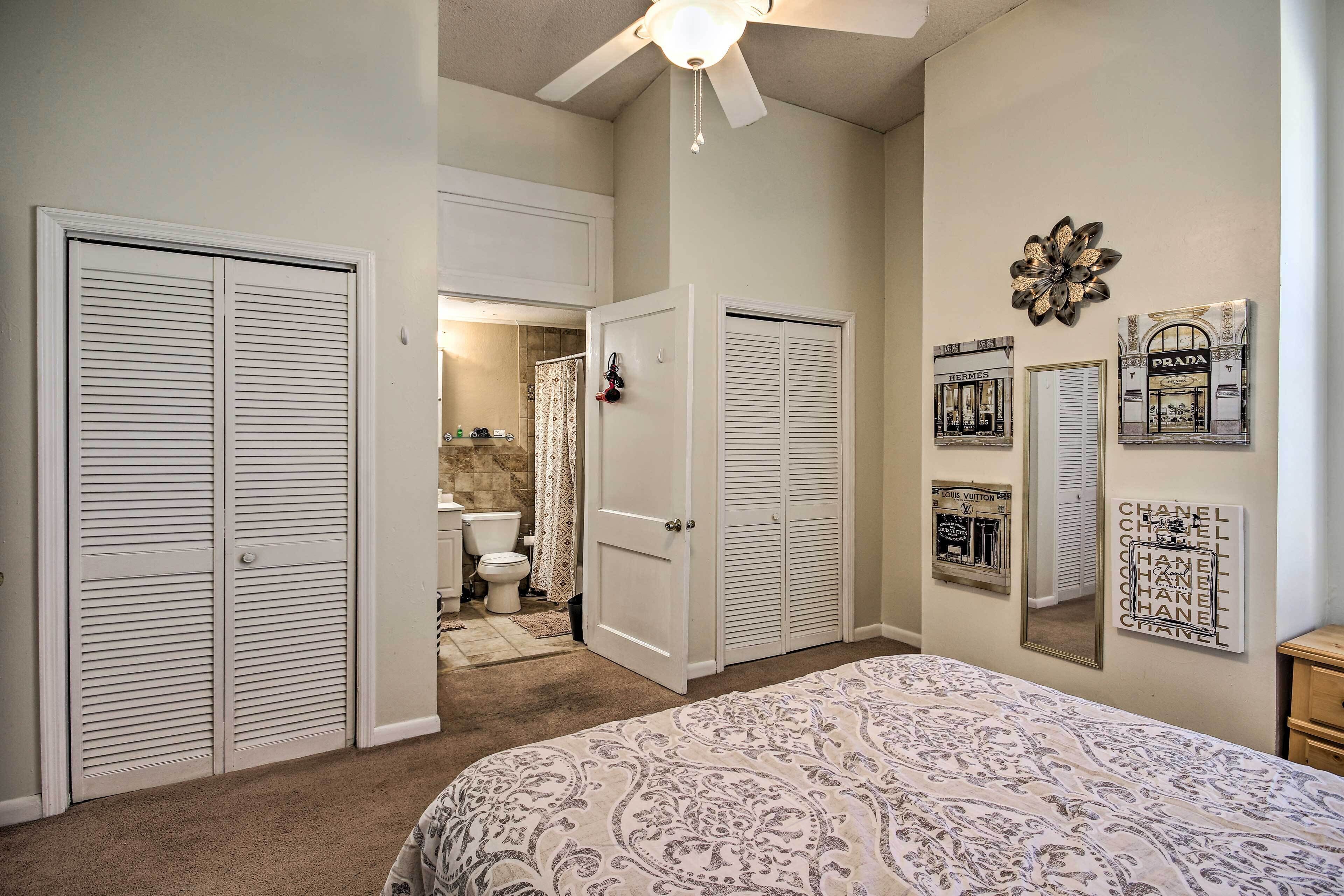 Une chambre à coucher comprenant un lit, deux placards, une salle de bain et des éléments de décoration murale.