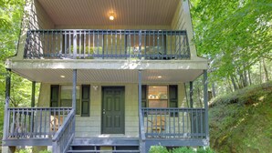 A two-story building with a balcony on the upper floor, a front door, and a staircase leading to the entrance. - Pet-friendly Ellijay Cabin in the Woods on 1 Acre! (Ellijay)