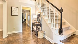A staircase with white railings and a black balustrade, leading to a landing with a framed sign and a small table with a lamp. - Family-friendly Athens Escape ~ 2 Mi to Uga! (Athens)