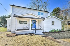 A two-story white house with a blue front door, a covered porch with two chairs, and a small attached garage. - Chic St Marys Home, 2 Blocks From Riverfront (St. Marys)