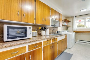 Uma cozinha com armários de madeira, micro-ondas, fogão e pia.