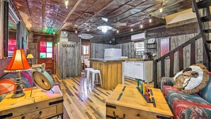 Ein rustikales Interieur mit Holzbalkendecke, einer Bar, einer Couch und einer Küche.