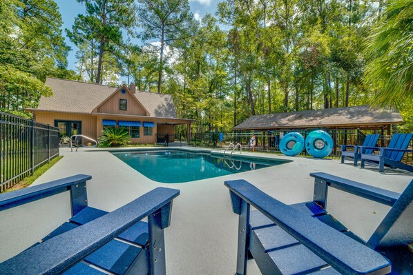Relax by the serene pool surrounded by lush greenery and a tranquil atmosphere.