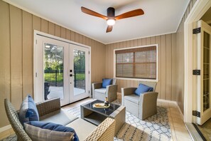 Relax in style with a ceiling fan overhead, wicker furniture, and a cozy seating area.