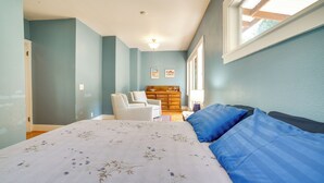 A bedroom with a bed, a chair, a dresser, and a window. - Historic Seattle Vacation Rental in Seward Park! (Seattle)