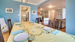 A dining area with a table set for four, chairs, and a light fixture above. - Historic Seattle Vacation Rental in Seward Park! (Seattle)