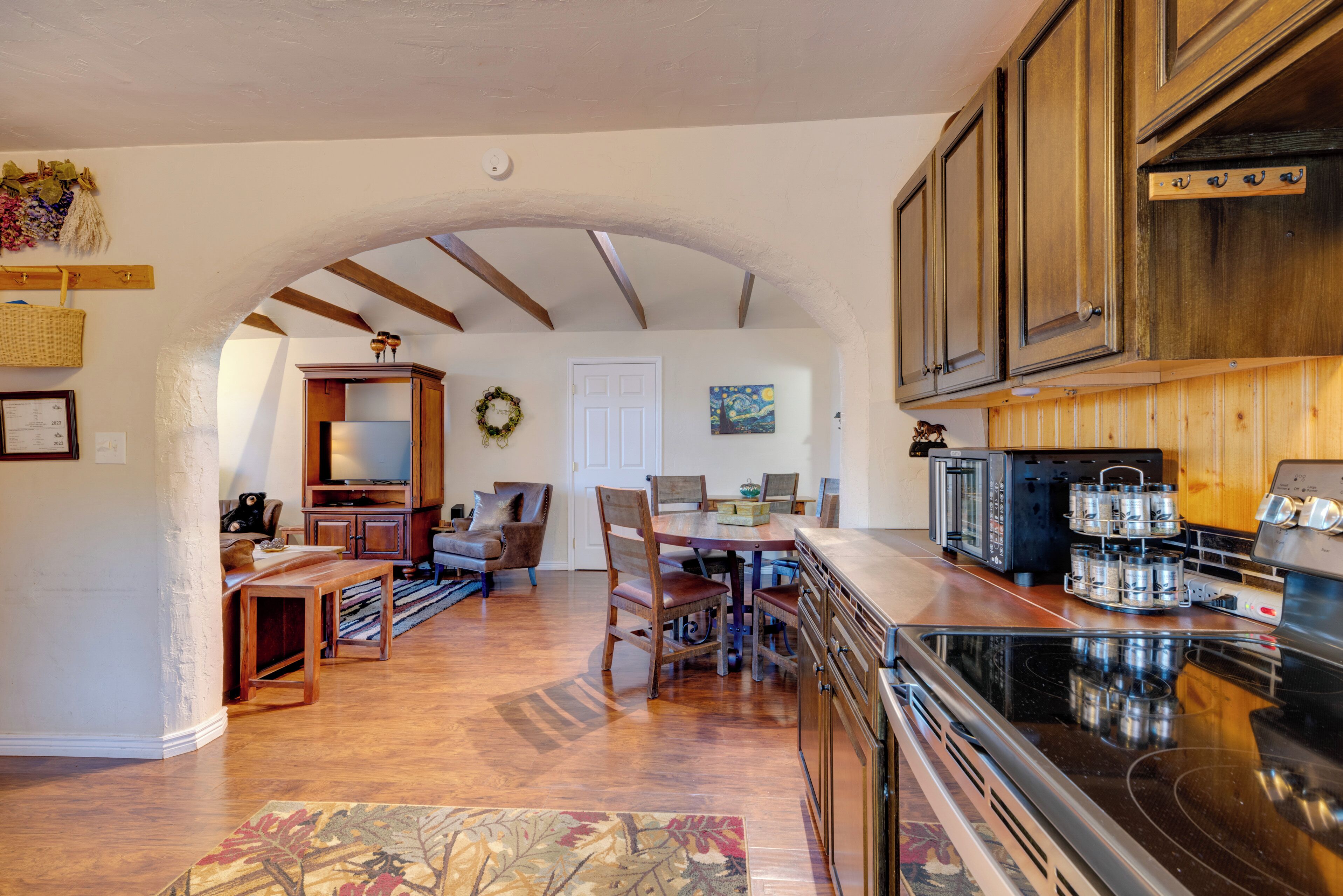 Une cuisine spacieuse, dotée de meubles en bois, d’une grande cuisinière et d’un coin repas avec des chaises et une table.