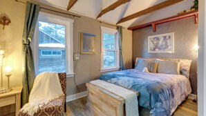 Une chambre à coucher avec un lit, une chaise, un banc et une fenêtre.