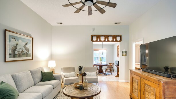 A living room with a sofa, chairs, a coffee table, a TV, and a ceiling fan. - Pet-friendly Darien Vacation Rental w/ Patio! (Darien)