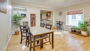 Un coin repas avec une table et des chaises en bois, un ventilateur de plafond et des plantes en pot.