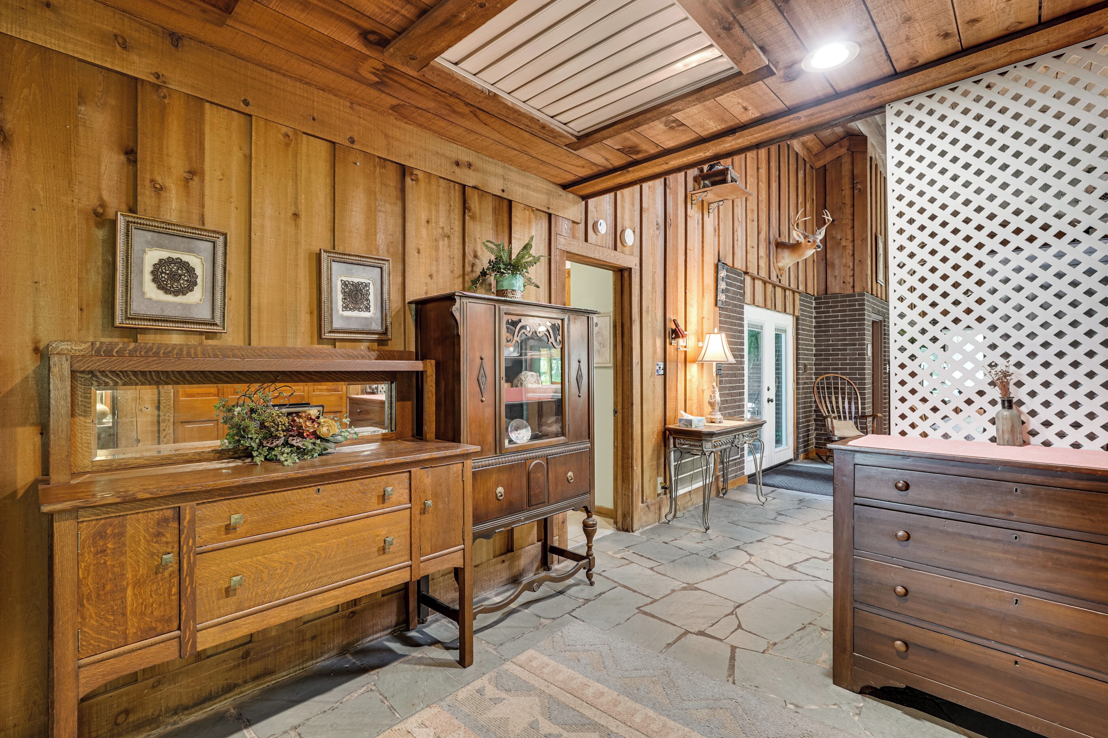 A wooden interior with a dresser, a mirror, and a cabinet.