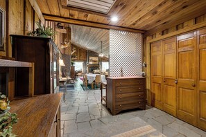 A rustic interior with a stone floor, wooden walls, a dining area, and a fireplace. - Clarks Hill Lake Area Home w/ Pool & Dock! (Lincolnton)