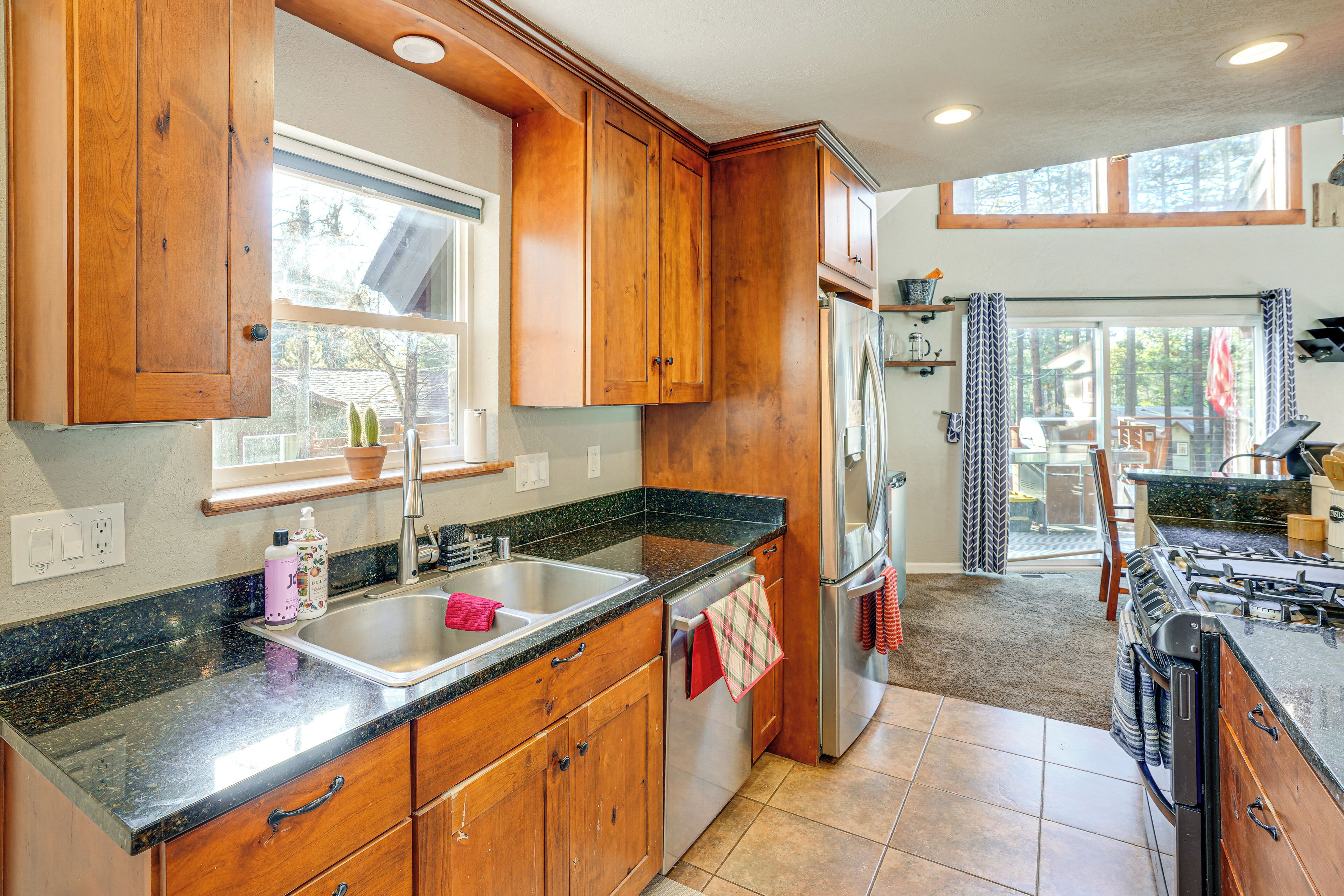A kitchen with wooden cabinets, a stainless steel sink, and a gas stove.