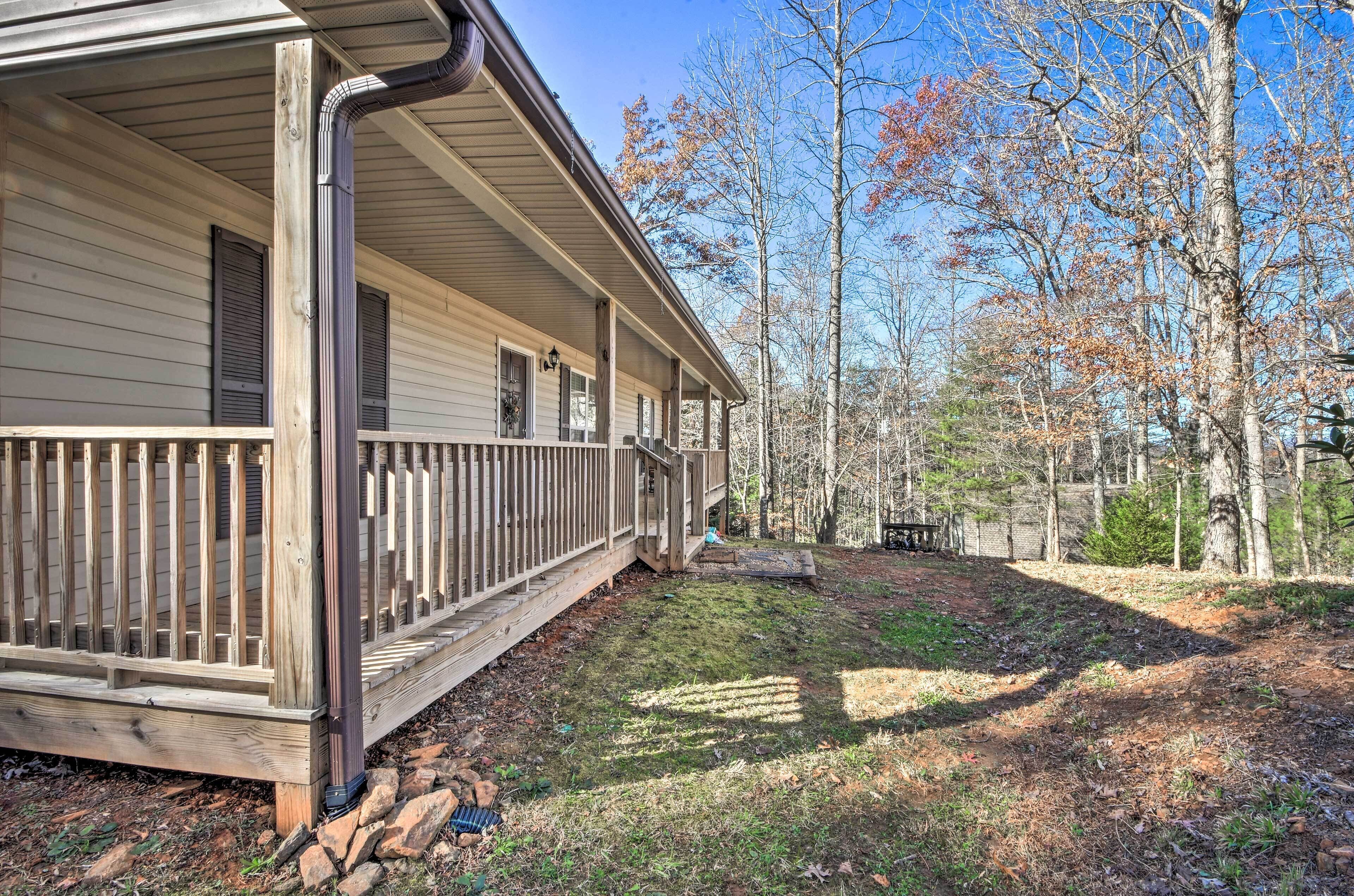A single-story house with a covered porch and a stone foundation.