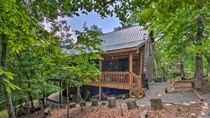 A rustic cabin with a wooden deck, surrounded by trees and a gravel path. - Dreamy Ellijay Resort Cabin w/ Game Room & Decks! (Ellijay)