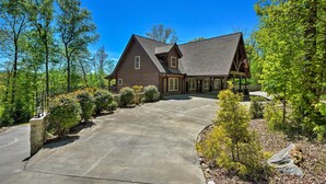 A two-story house with a stone foundation, a concrete driveway, and a well-maintained garden with various shrubs and trees. - Trenton Cabin w/ Hot Tub - 14 Mi to Lookout Mtn! (Trenton)