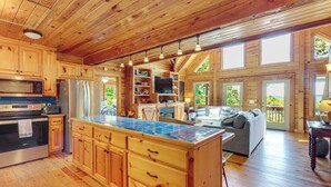 Ein Holzblockhaus-Innenraum mit Küche, Essbereich und Wohnzimmer.