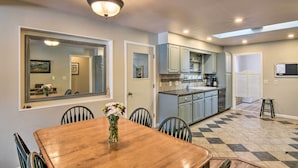 A dining area with a wooden table and chairs, a vase of flowers, and a large mirror on the wall. - 0651: Central Salida Home 5 Blocks to Dtwn & River (Salida)