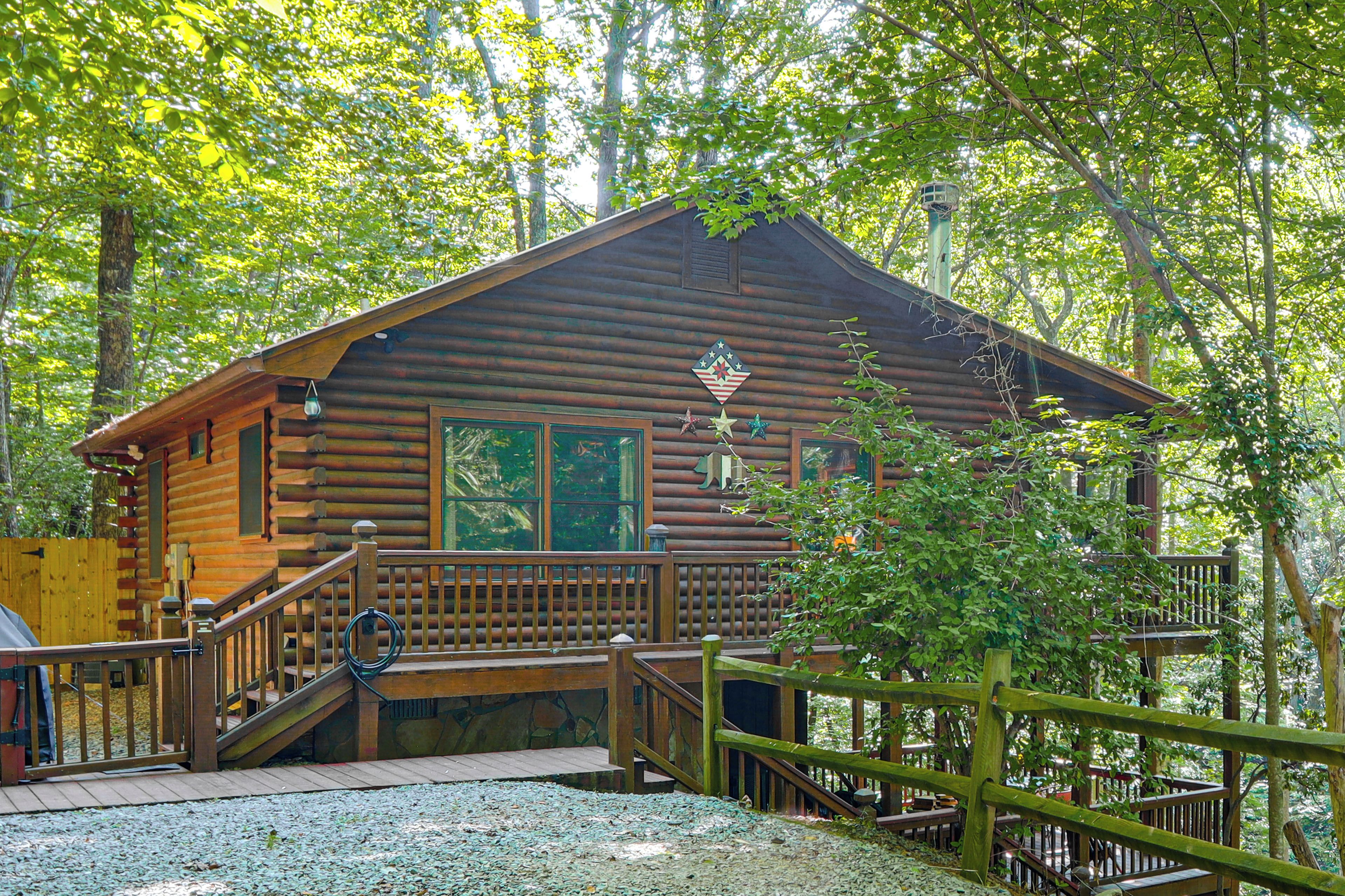 Una baita di legno con un portico, una scala e vista sulla foresta circostante.