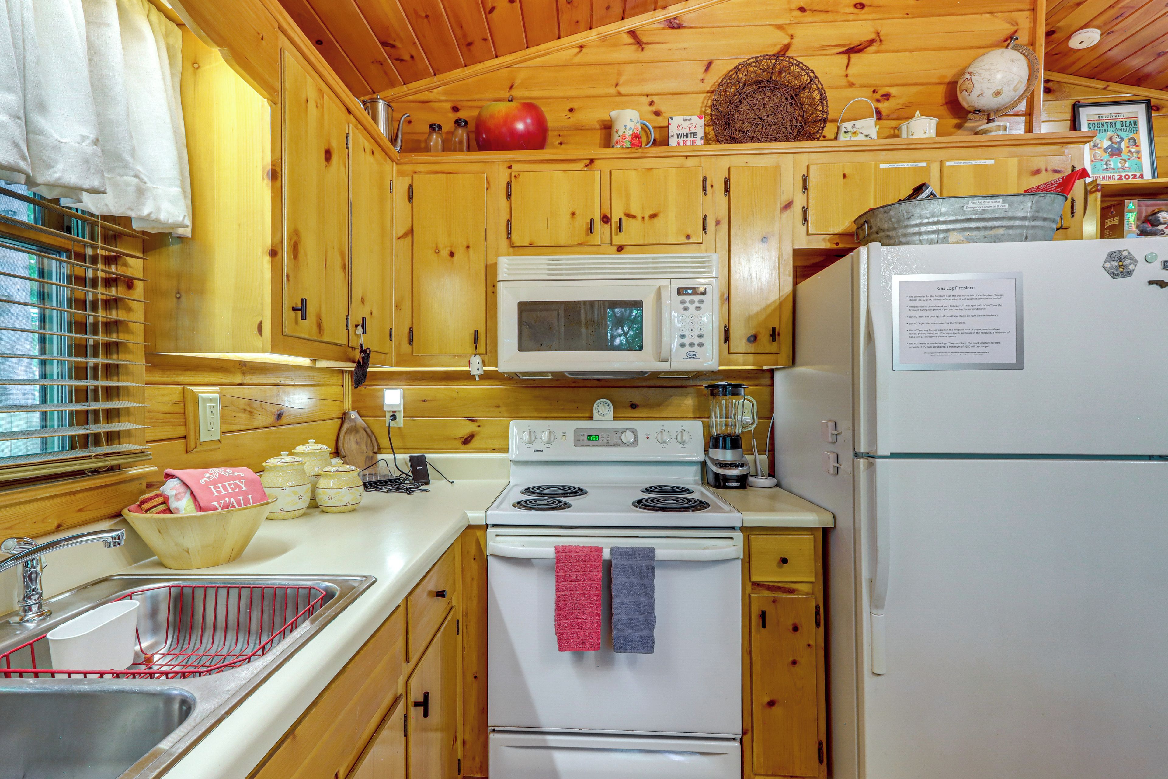 Une cuisine compacte avec des meubles en bois, un four à micro-ondes, une cuisinière et un réfrigérateur.
