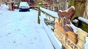 A wooden sign with carved animal figures and the text 'Cabin' in a snowy outdoor setting. - Peaceful Blue Ridge Cabin w/ Decks & Fire Pit (Blue Ridge)