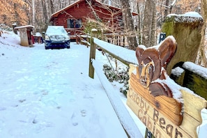 A wooden sign with carved animal figures and the text 'Cabin' in a snowy outdoor setting. - Peaceful Blue Ridge Cabin w/ Decks & Fire Pit (Blue Ridge)