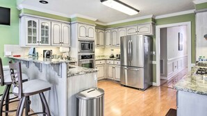 A modern kitchen with white cabinetry, stainless steel appliances, and a granite countertop. - Gorgeous Evans Retreat < 14 Mi to Augusta! (Evans)