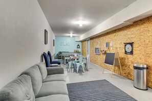 A modern room with a grey sofa, a small table, and a wooden accent wall.
