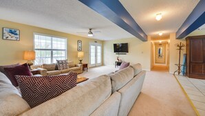 A living room with a beige sectional sofa, a lamp, and a television.
