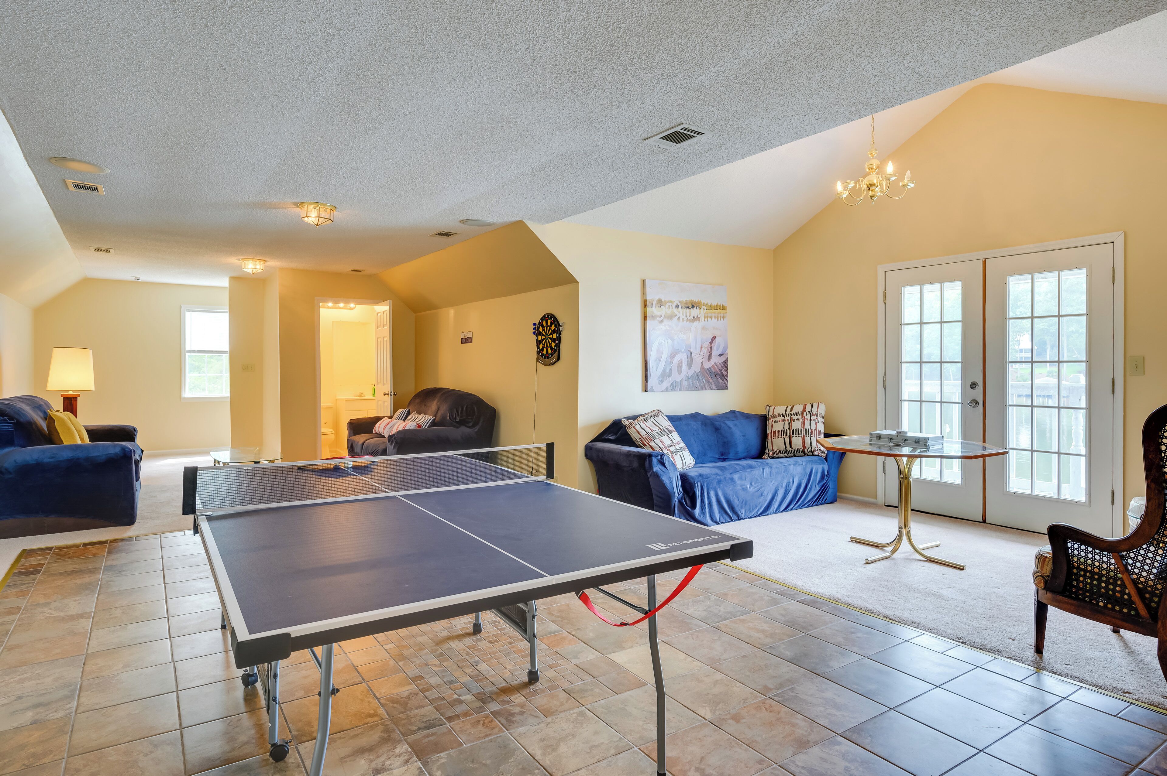 Un salon spacieux équipé d’une table de ping-pong, de sièges confortables et d’une grande fenêtre laissant entrer la lumière naturelle.