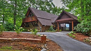 Eine rustikale Lodge mit Steinaußenwand, Holzbalkon und einer Veranda.