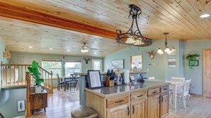 Una cocina amplia con armarios de madera, una isla central y un comedor con mesa y sillas.