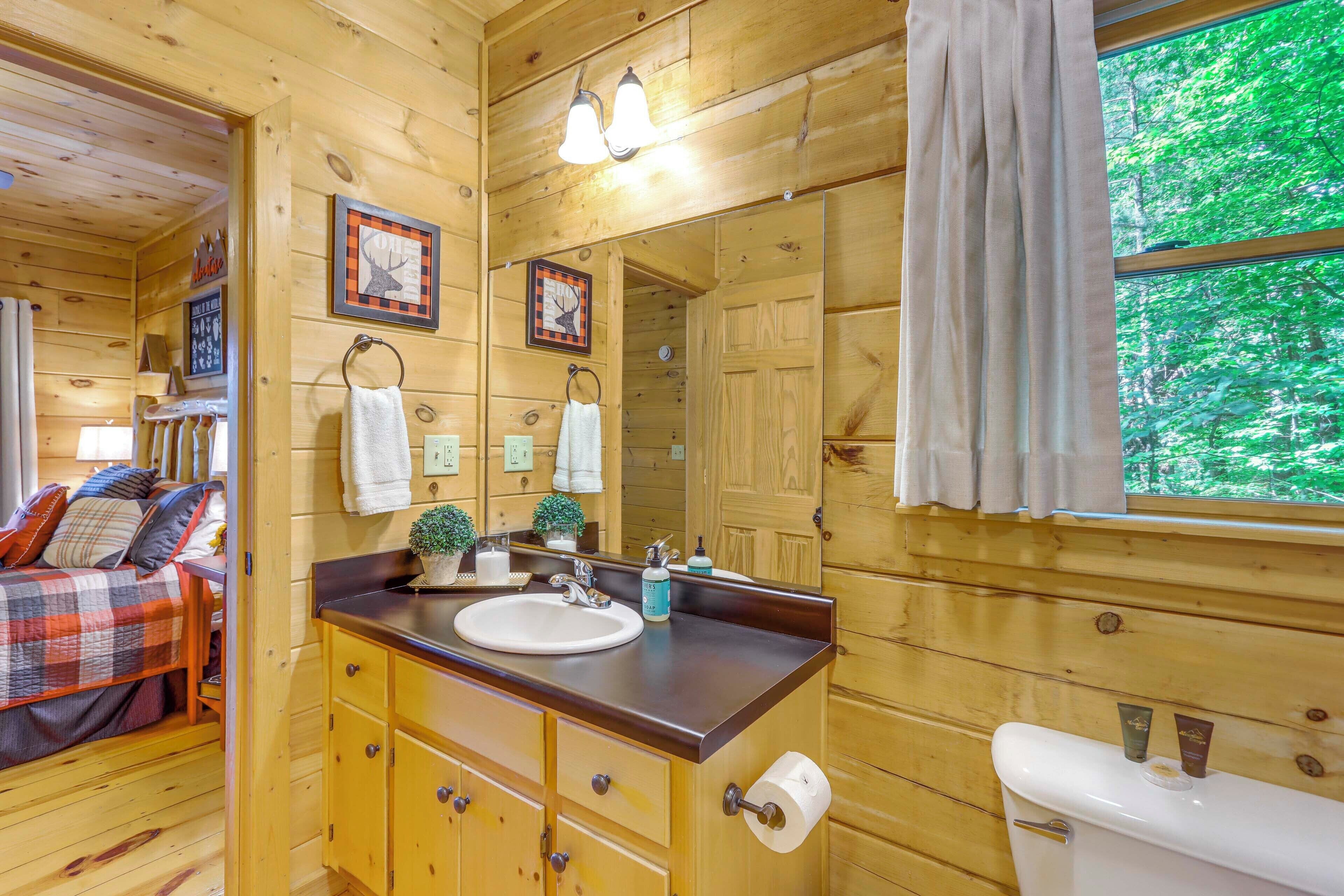 L’intérieur d’une cabane en bois comprend une salle de bain équipée d’un lavabo, d’un miroir et de toilettes.