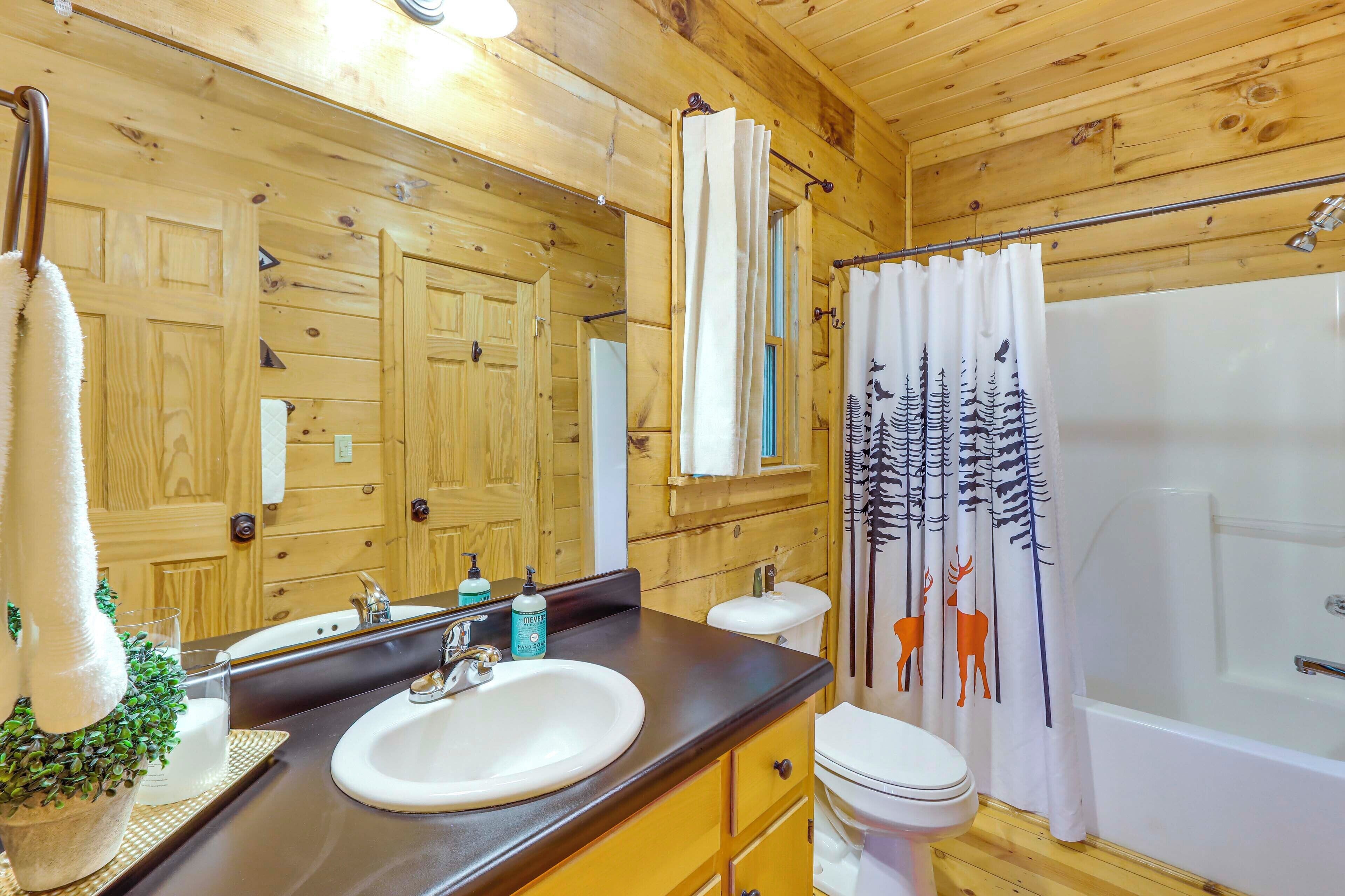 A wooden cabin bathroom with a sink, toilet, and shower.