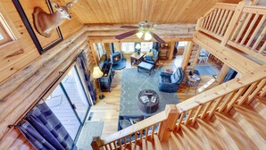 A wooden cabin interior with a ceiling fan, a mounted deer head, and a cozy living area with a fireplace. - Lake Blue Ridge Cabin by the Chatahoochie Forest (Blue Ridge)
