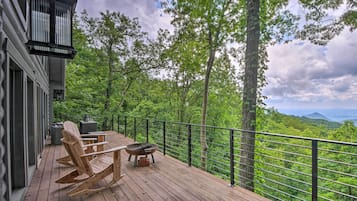 Relax on the deck with a view of the lush forest and distant mountains.