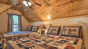Un dormitorio acogedor con techos de madera y una cama grande con colcha.