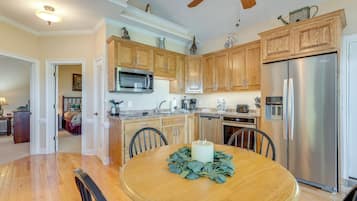Una cocina moderna con armarios de madera, electrodomésticos de acero inoxidable y una mesa de comedor con un centro de velas.