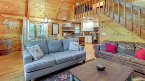 Eine geräumige Hütte mit Schlafzimmer im Zwischengeschoss, Essbereich und Küche.