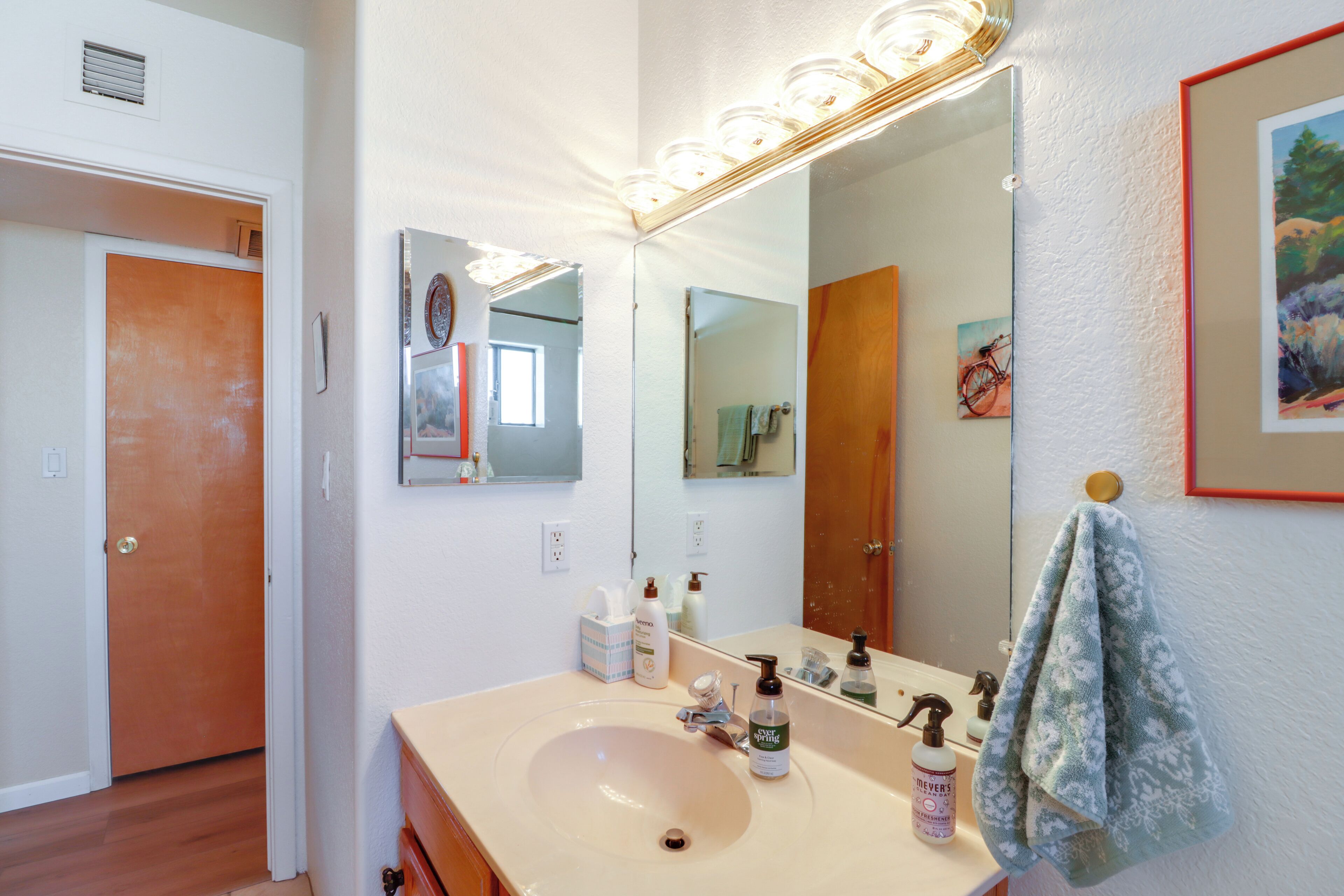 A bathroom with a sink, mirror, and various toiletries.