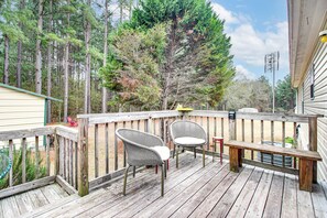 A wooden deck with two wicker chairs and a bench, surrounded by trees and a house. - Fireside Nights + Family Fun! Quiet Claxton Home (Claxton)